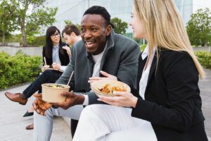 Happy multiracial business people having a lunch break outside office