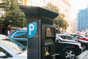 Machine for paying parking. Close up machine for paying parking on background of blurry cars