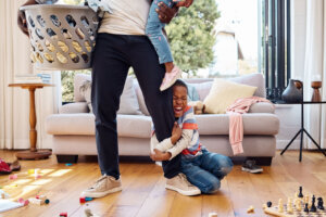 Shot of a little boy throwing a tantrum while holding his parent's leg at home