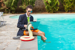 Funny Young Businessman with SwimmingTrunks next to the Pool