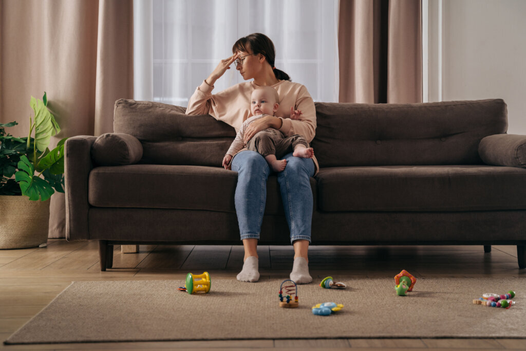 Young tired woman suffering from postnatal depression at home