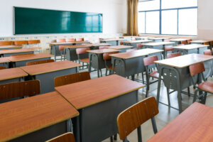 Empty classroom with desks, chairs and chalkboard