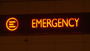 Emergency Department Service Red Sign on Hospital Building at Night