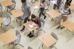 Elevated view of students writing their GCSE exam in classroom