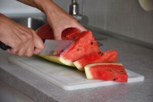 Cutting watermelon on plastic cutting board