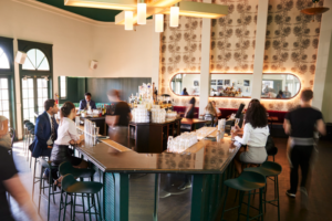 Interior Of Busy Cocktail Bar In Restaurant With Staff Serving Customers