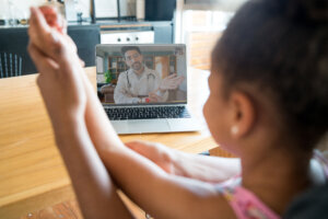 Mother and daughter on a video call with doctor.