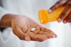 Shot of an unrecognizable person taking tablets at home