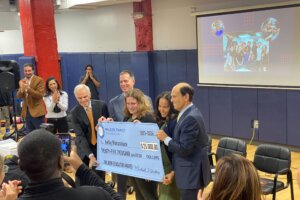 Kelly Maranchuck stands with an oversized check