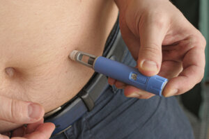 Obese fat man injecting Semaglutide Ozempic injection control blood sugar levels