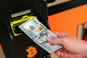 Atm bitcoin cryptocurrency machine. Woman withdraw american dollar bill cash. Usd hundred money payment on virtual crypto currency btc wallet. Bitcoin BTC ATM Cash Machine.