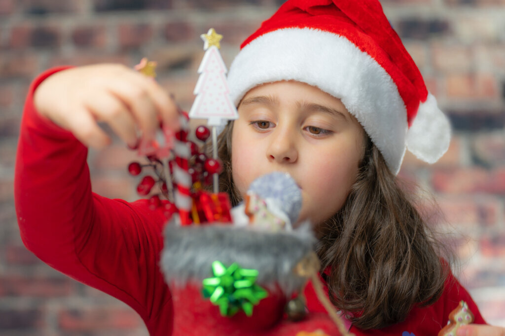 Child in Santa red cloth with red Santa boot.