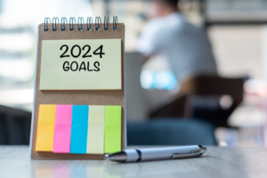 2024 Goal word on note paper with pen on wooden table. Resolution, strategy, solution, goal, business, New Year New You and happy holiday concepts