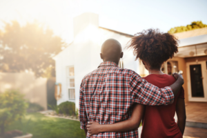 Back view, black couple and hug outdoor at house, real estate and new loan for luxury home. Man, woman and people in front of property investment, moving and dream neighborhood for building mortgage