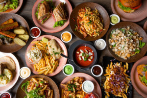 Snack, junk, fast food on table in restaurant. Soup, sauce ornament, grill hamburger, french fries, pasta with sea food