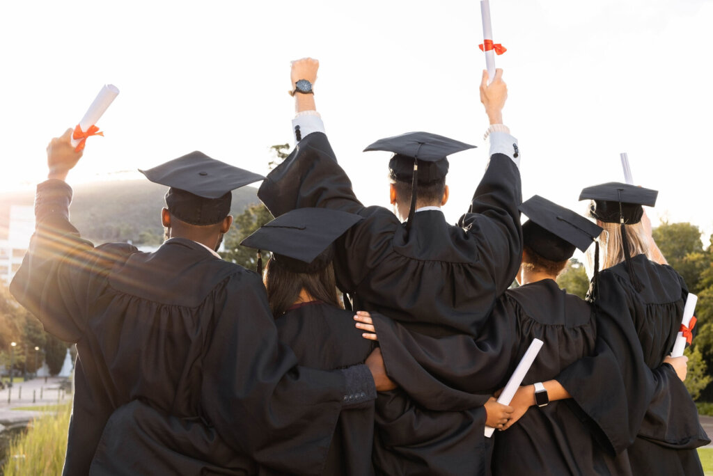 Graduation, group and back view of students celebrate education success. Behind of excited graduates at campus celebration for study goals, university award and learning motivation for happy future