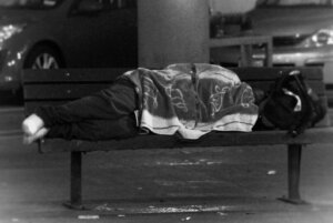 Person sleeping on bench near Bethesda Metro station