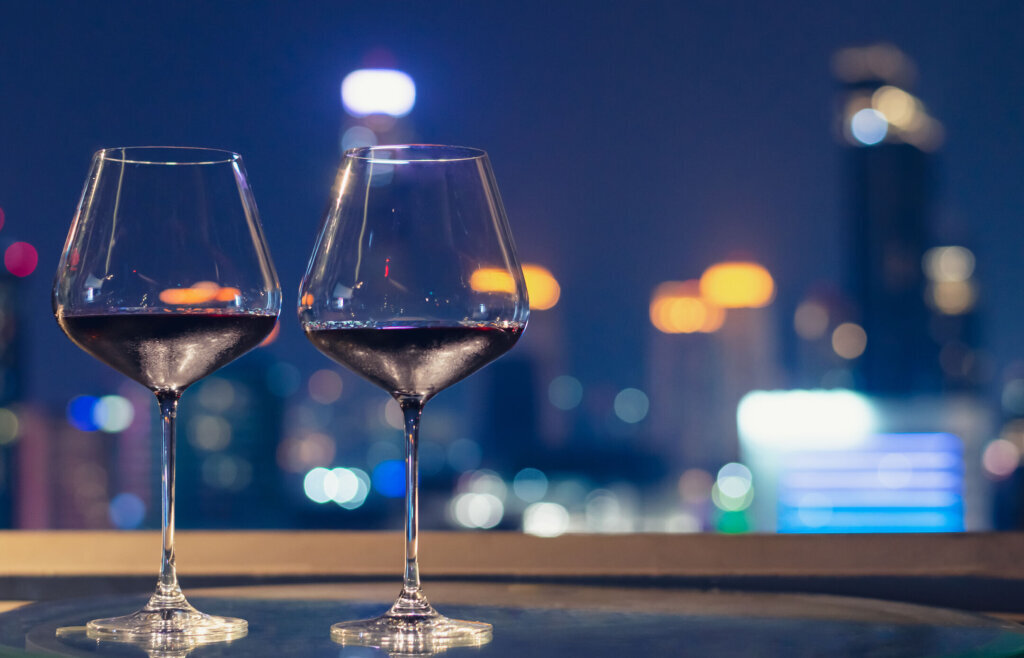 Two glasses of red wine on table of rooftop bar.