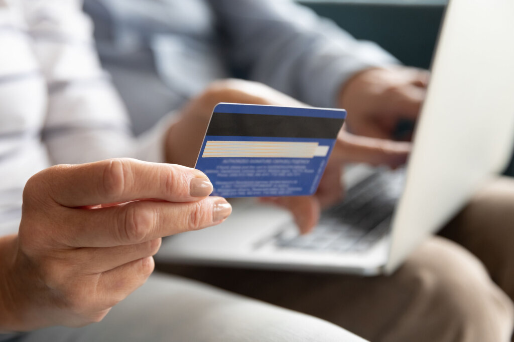 Female holding credit card making online payment, closeup view
