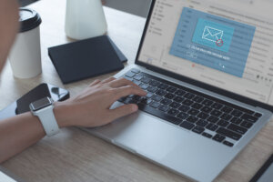 Blocking spam e mail, warning pop up for phishing mail, network security concept. Business woman working on laptop computer at home with warning window