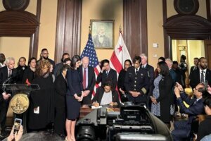 D.C. Mayor Muriel Bowser signs the "Secure D.C." bill. (WTOP/Scott Gelman)