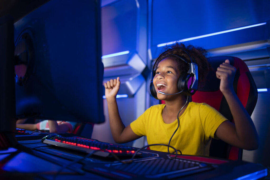 Cute young girl feeling happy and excited for winning computer video game.