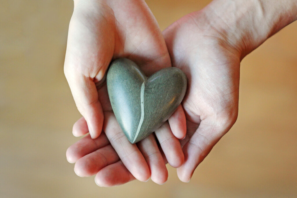 Hands holding a stone heart