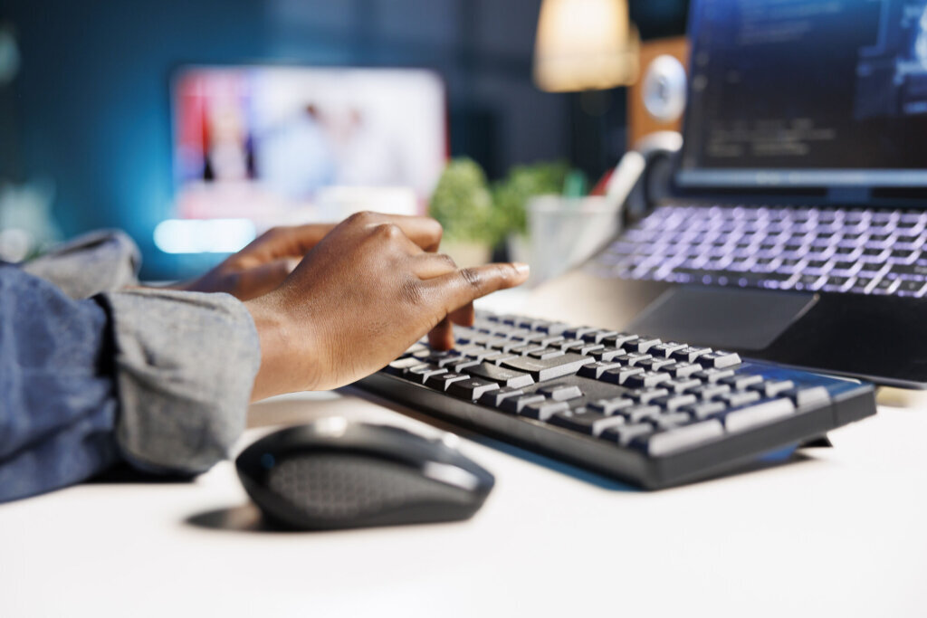 Person using keyboard to type in code
