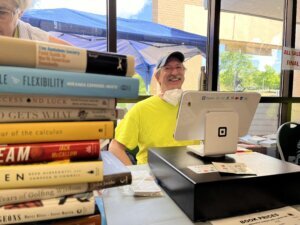 A man smiling behind a desk