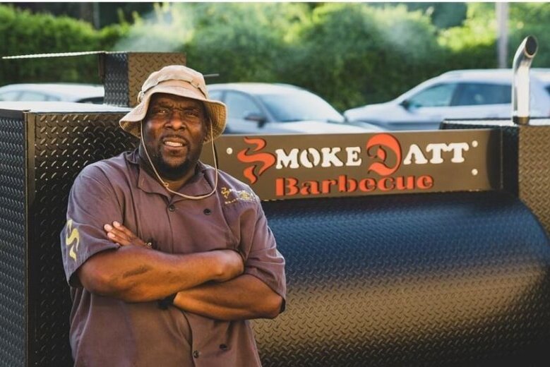 Man next to barbecue smoker
