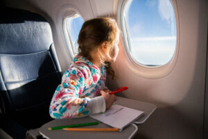 Child drawing a picture with crayons in an airplane.