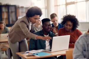 African Americans college students e leaning with their teacher during a class.