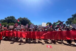 Activists holding red banner outside The White House.