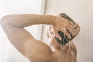 Morning shower young man showering taking a hot bath washing hair panorama banner home lifestyle background