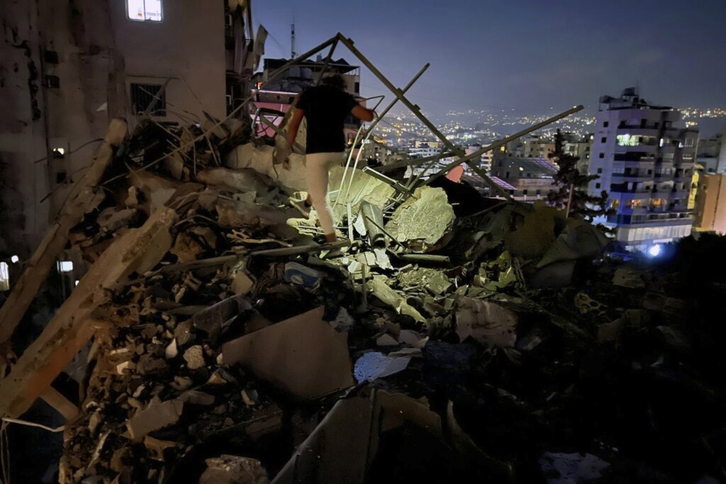 A man inspects a destroyed building
