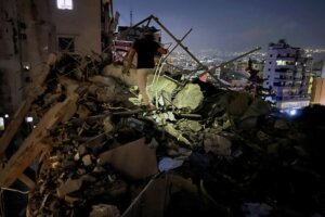 A man inspects a destroyed building