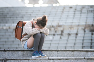 Elementary school students sitting on the steps and crying