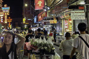 Traffic and people walking on Yaowarat road in Chinatown at night