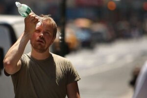 Man cooling himself with a bottle of water