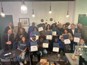 Graduates hold their diplomas from the nonprofit Tzedek DC.