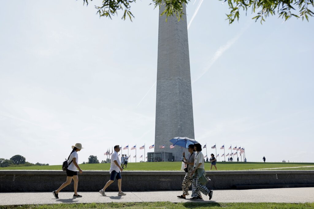 People walk near the Washington Monument during heat wave