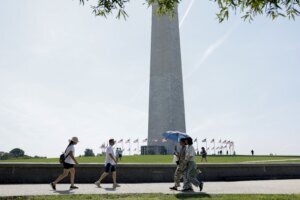 People walk near the Washington Monument during heat wave