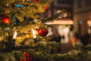 Christmas old town in the evening in Europe.Festive street decorations in European cities. Christmas tree with gifts, garlands and people walking out of focus.