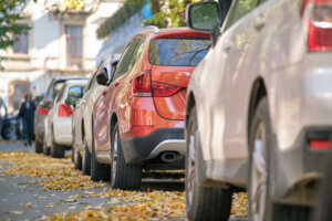 City traffic with many cars parked in line on street side