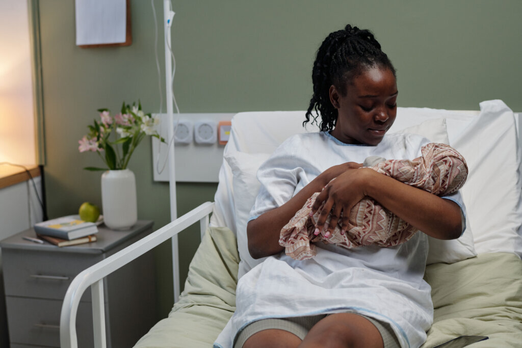 Holding Newborn Baby in Hospital Bed With Look of Love