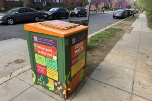 A food waste bin on a sidewalk