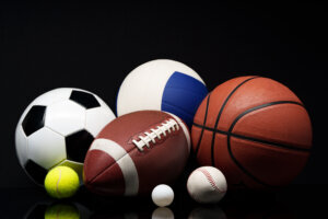 Various sports equipment on black background studio shot
