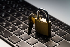 Computer keyboard and padlock on dark background