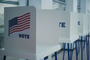 Voting booths with American flag logo in polling station office.