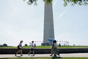 People walk near the Washington Monument during heat wave